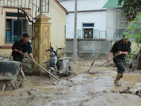 Cảnh sát cơ động giúp dân dọn bùn đất sau mưa lũ