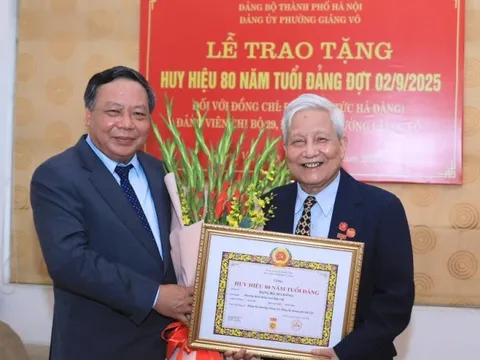 Phó Bí thư Thường trực Thành ủy Hà Nội Nguyễn Văn Phong trao Huy hiệu 80 năm tuổi Đảng cho nhà báo Hà Đăng